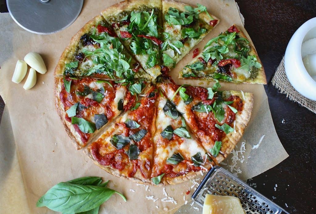 Pizza with greens on top. 